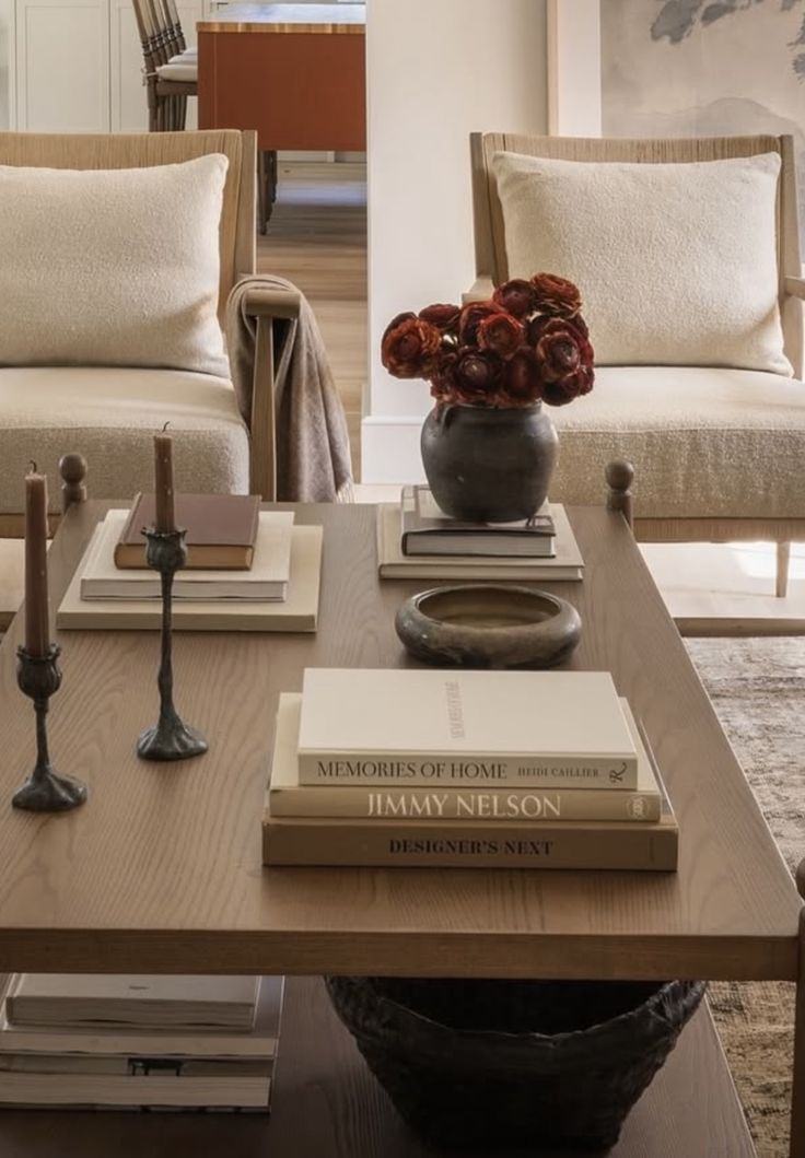 Coffee table styled with stacked books, a ceramic vase and taper candlesticks