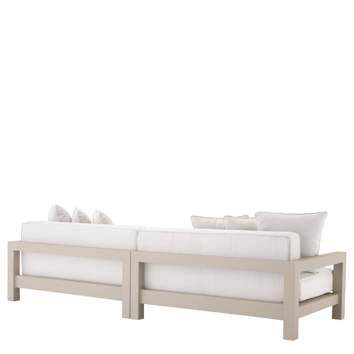 Sectional sofa with white cushions on a light wood frame against a white background