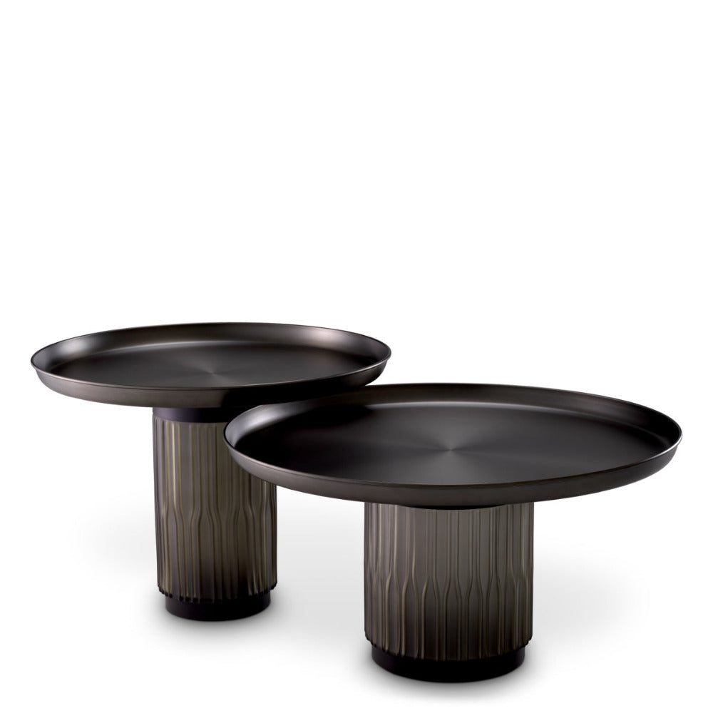 Two black coffee tables with textured cylindrical bases on a white background