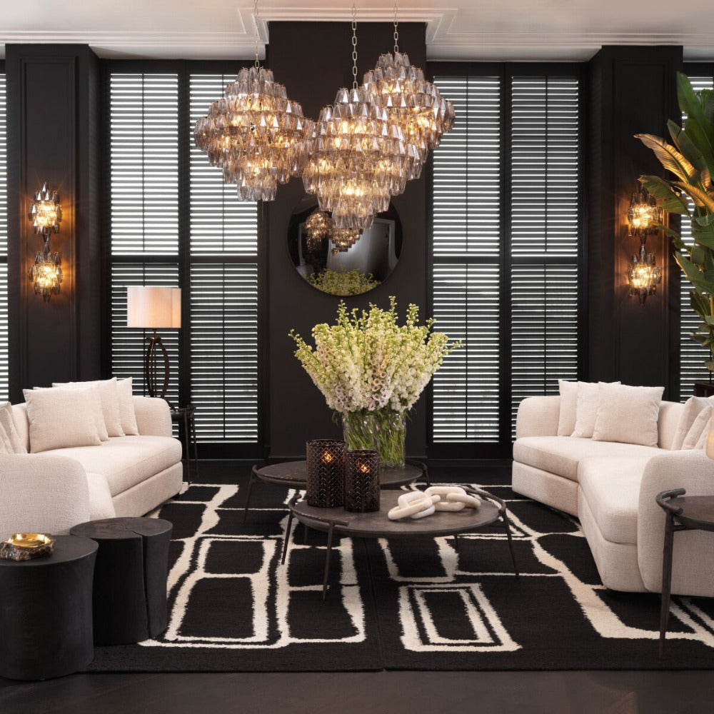 Luxurious living room with white sofas, black coffee table, and decorative elements.