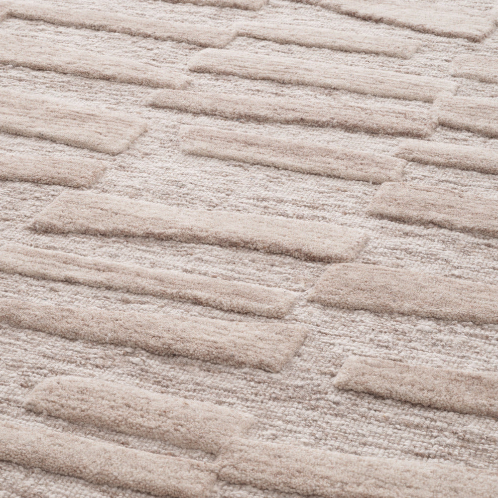 Close-up of a textured beige carpet with wavy pattern