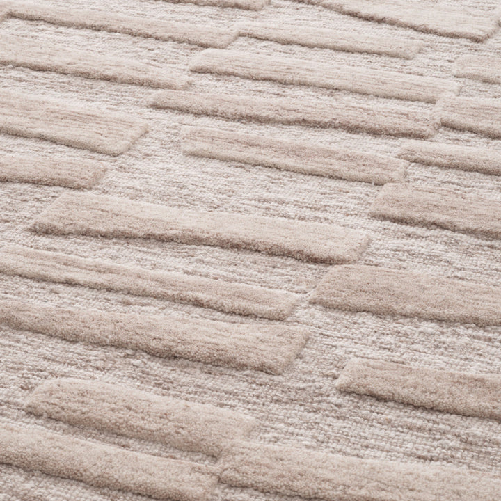 Close-up of a textured beige carpet with wavy pattern