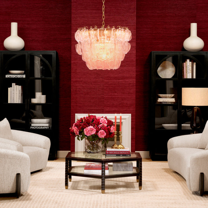 Living room with red walls, white furniture, and a chandelier.