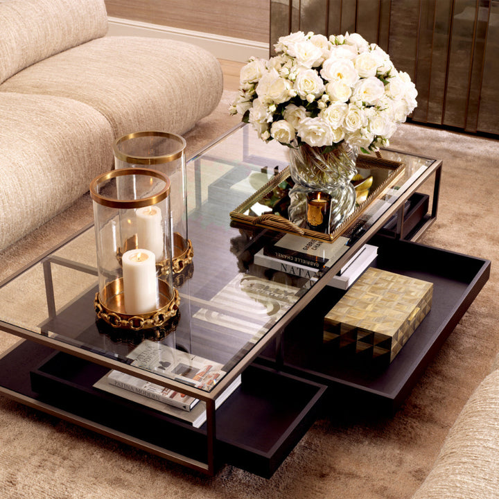 Coffee table with decorative items including candles and flowers in a living room setting.