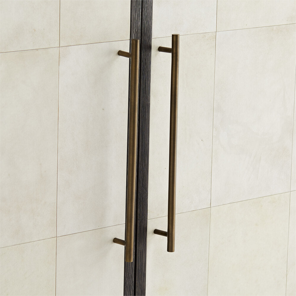 Bronze door handles on a white door with a tiled background