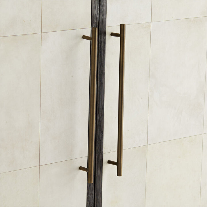 Bronze door handles on a white door with a tiled background