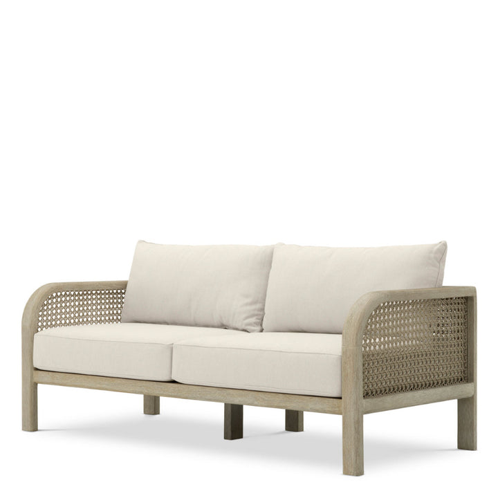 Beige outdoor sofa with wicker frame on a white background