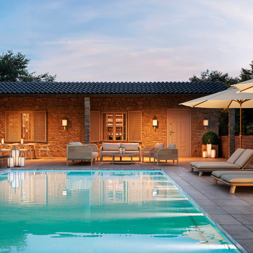 Pool area with lounge chairs, table, and outdoor furniture in a residential setting.