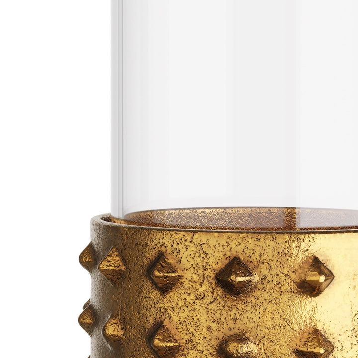 Decorative glass candle holder with textured gold base on a white background