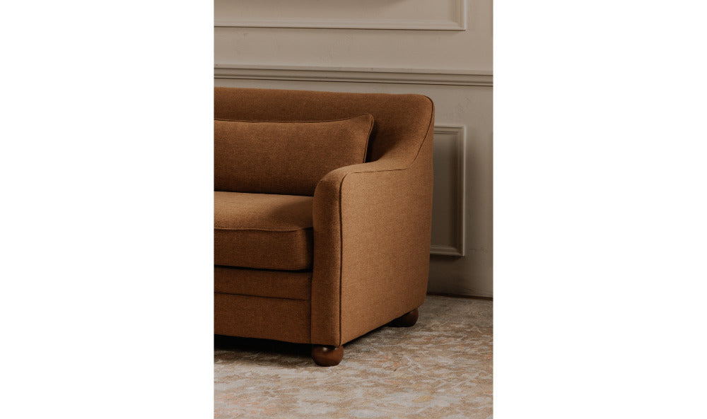 Brown sofa in a room with beige walls and carpet.