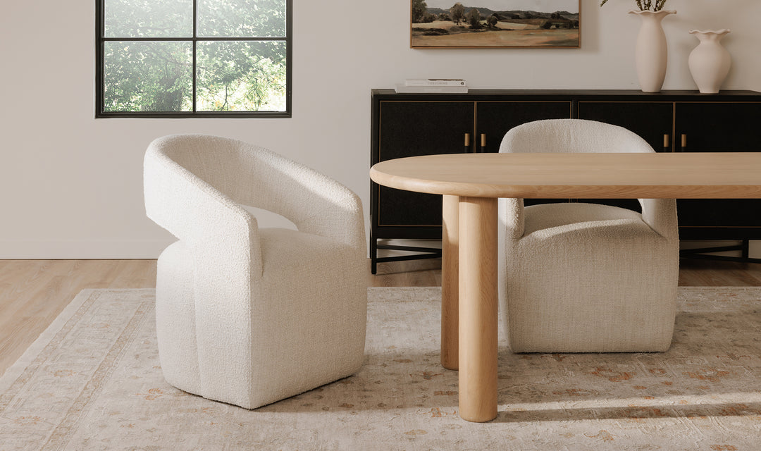 Modern dining room with a wooden table and white chairs.