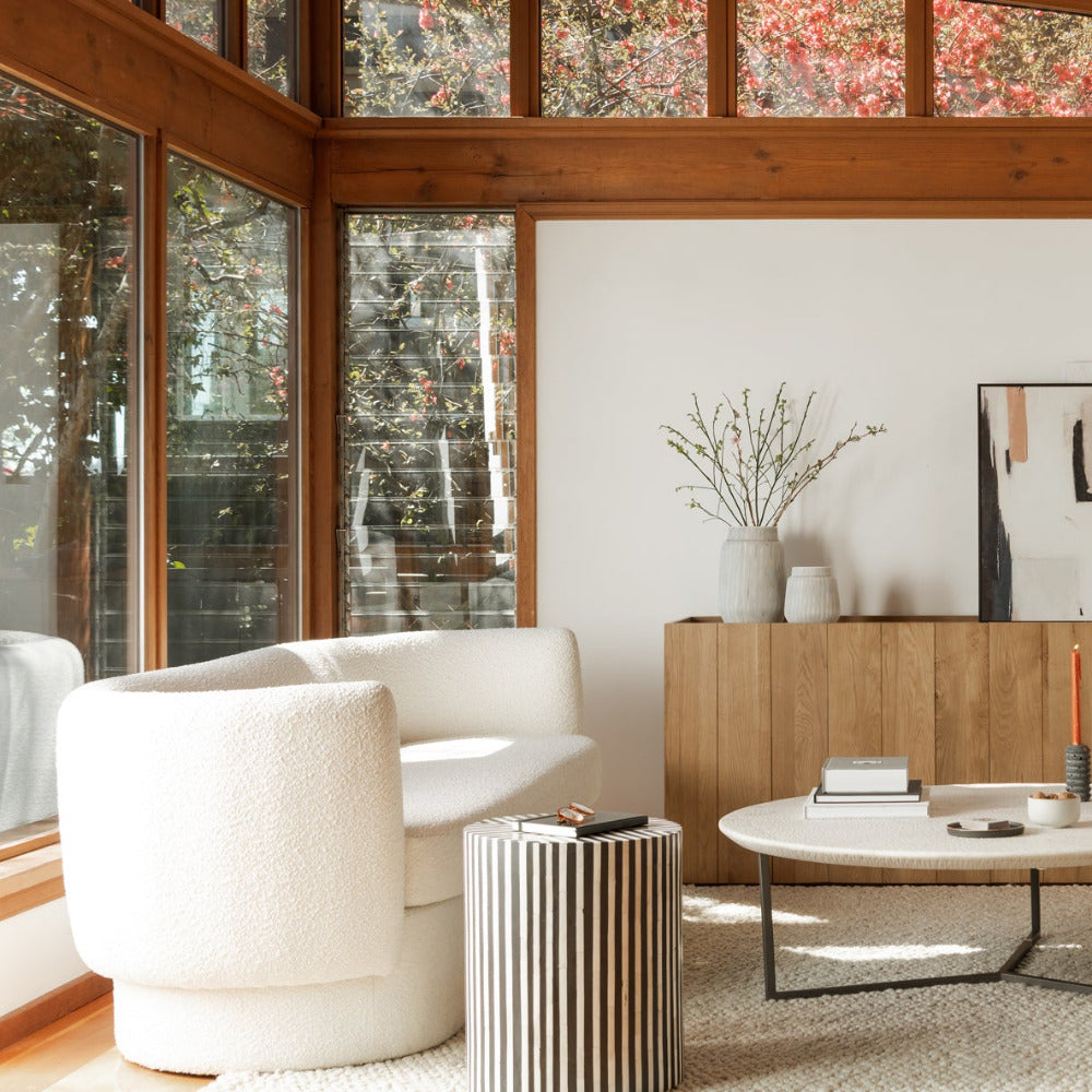 Modern living room with white sofa, side table, and decorative items.