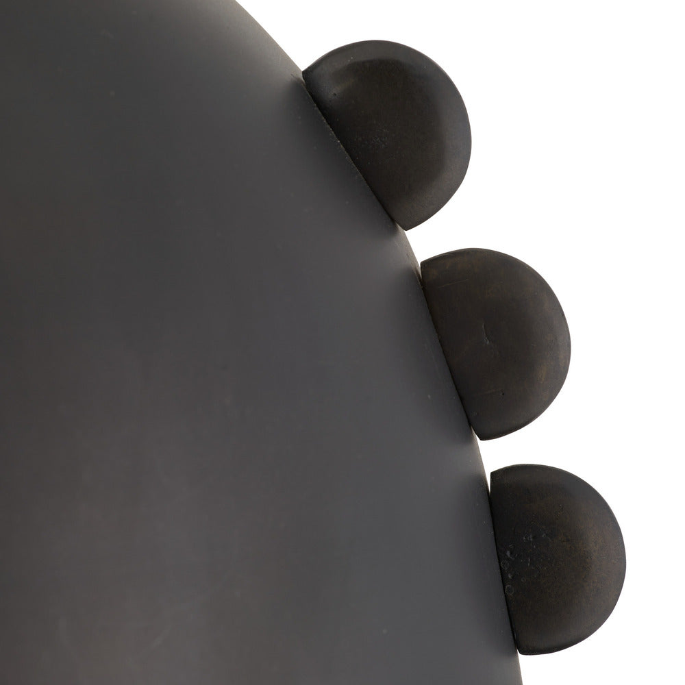 Close-up of a dark gray pendant with three spherical protrusions.