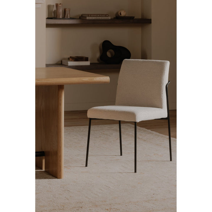 Ivory chair in front of a wooden desk in a minimalistic room.