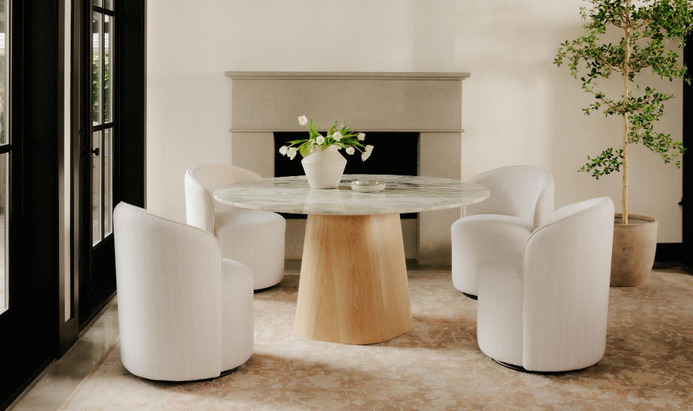 Modern dining room with a round table and white chairs.