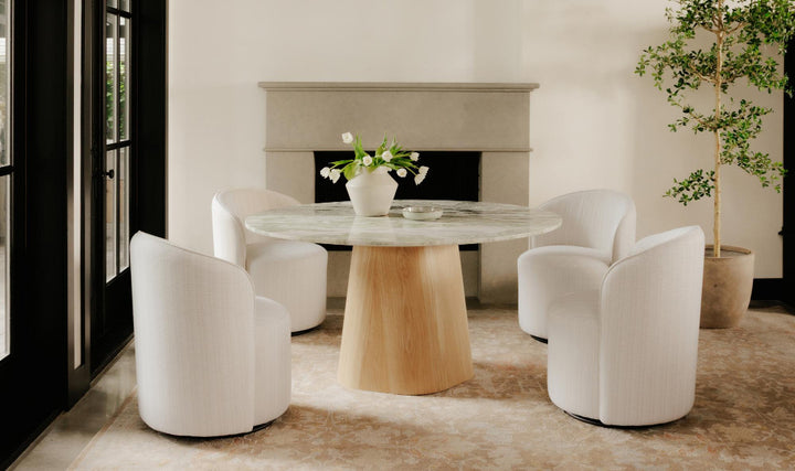 Modern dining room with a round table and white chairs.
