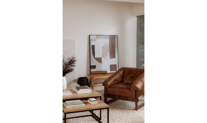 Modern living room with a brown leather sofa and abstract art on the wall.