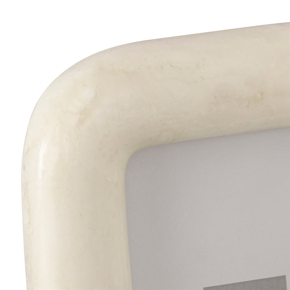 Close-up of a white picture frame with a curved edge on a white background