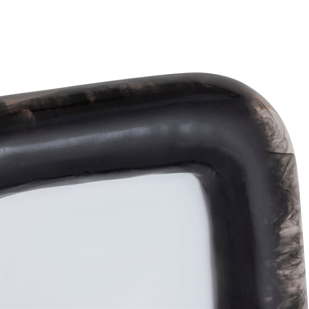 Close-up of a black resin picture frame with curved corners