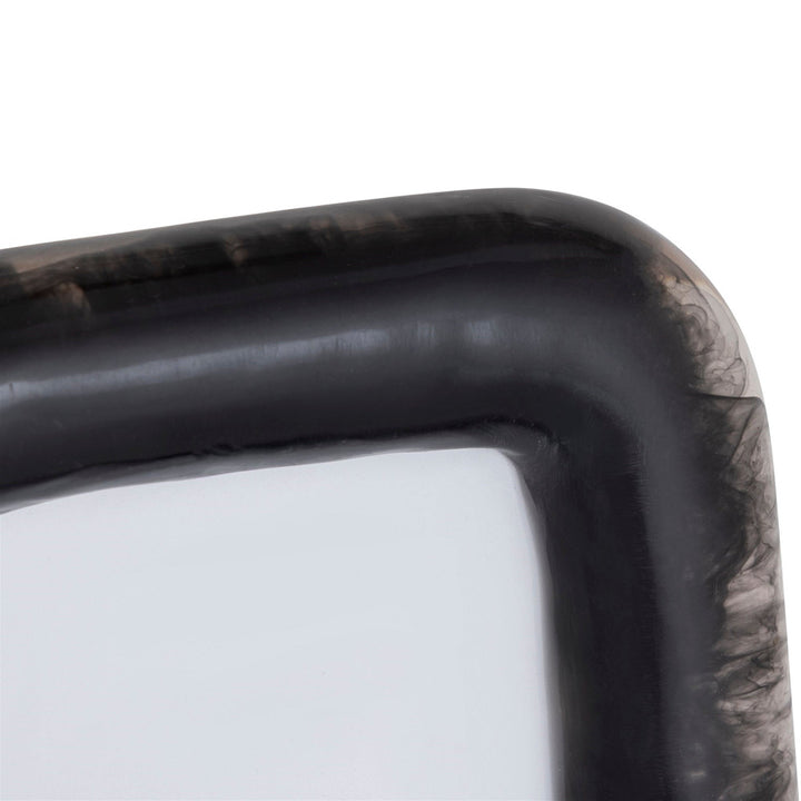 Close-up of a black resin picture frame with curved corners