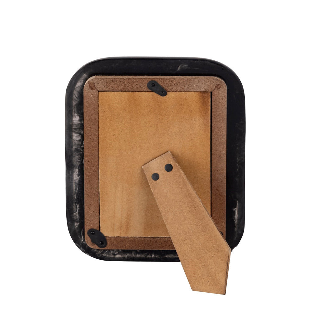 Black resin frame with a wooden backer on a white background