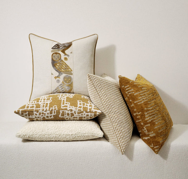 Decorative pillows with various patterns on a white sofa against a light background
