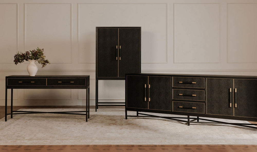 Modern black furniture set including a sideboard, cabinet, and console table in a room with white paneled walls.