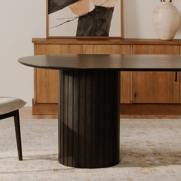 Dining room with a dark wooden table and beige chair, light-colored walls, and a window.