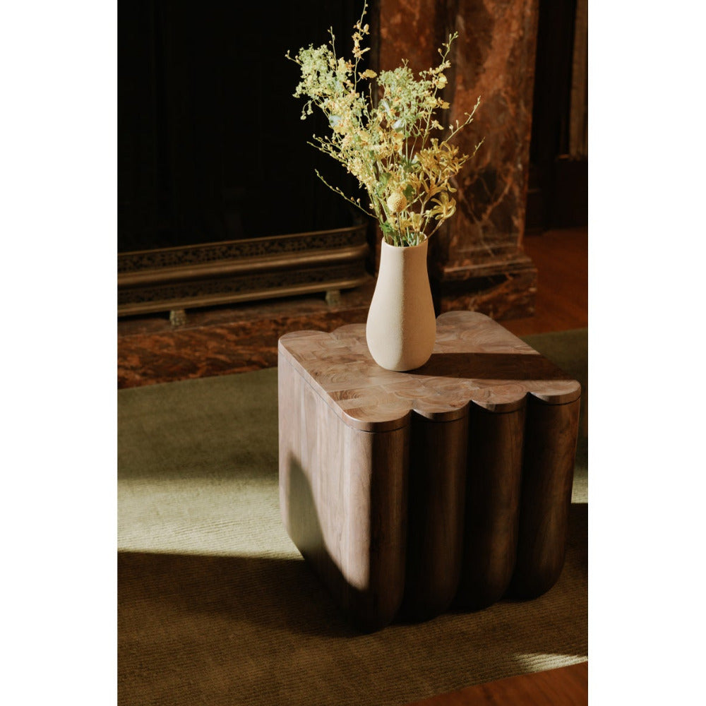 White vase with dried flowers on a wooden side table