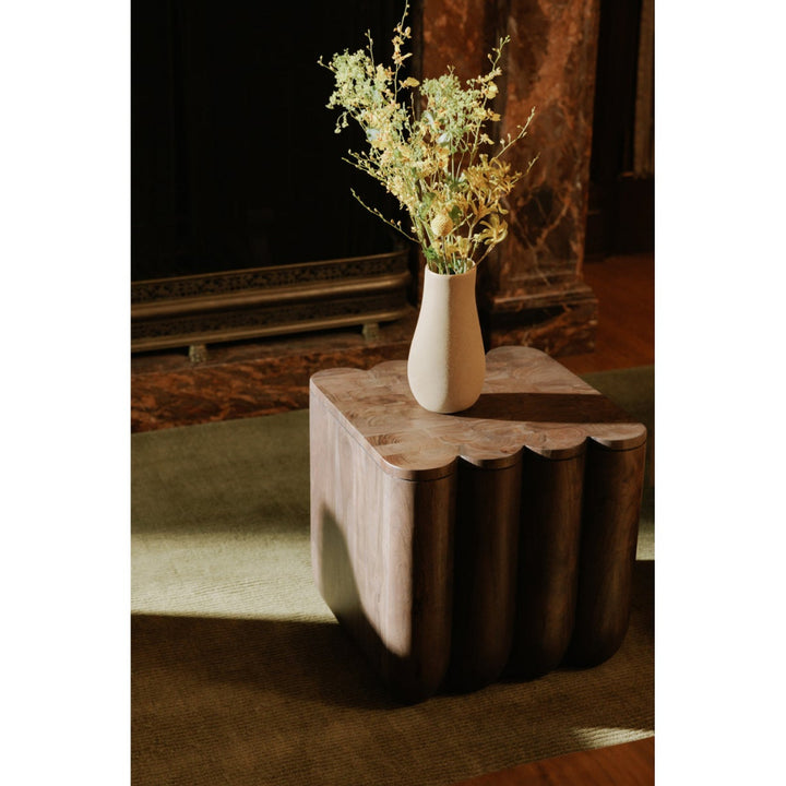 White vase with dried flowers on a wooden side table