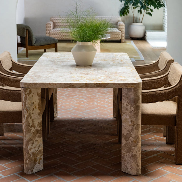 Dining table with four chairs in a room with a textured floor and wooden cabinet.