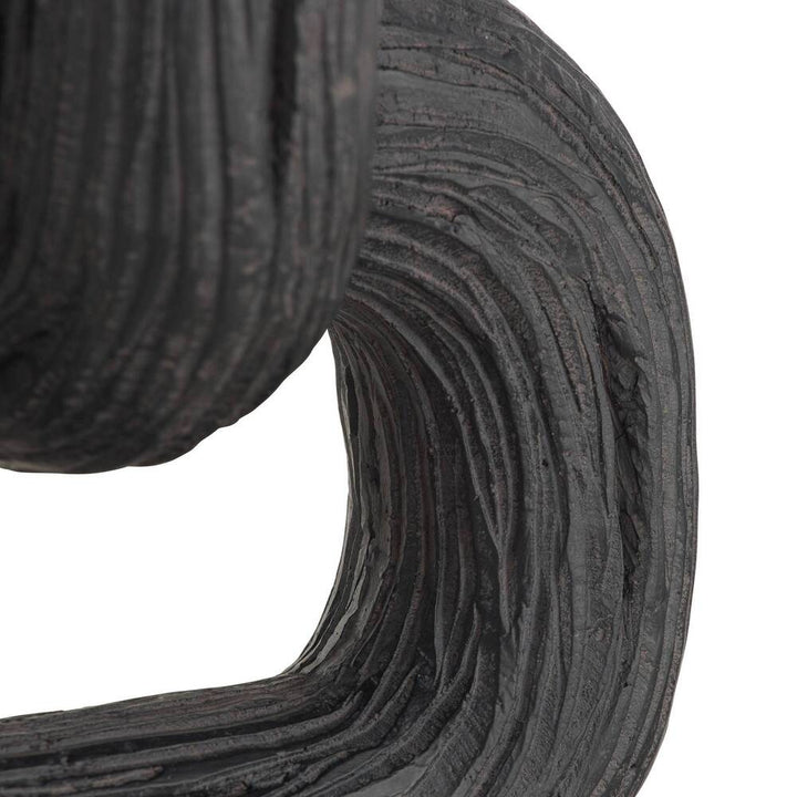 Close-up of a roll of black sculpture on a white background
