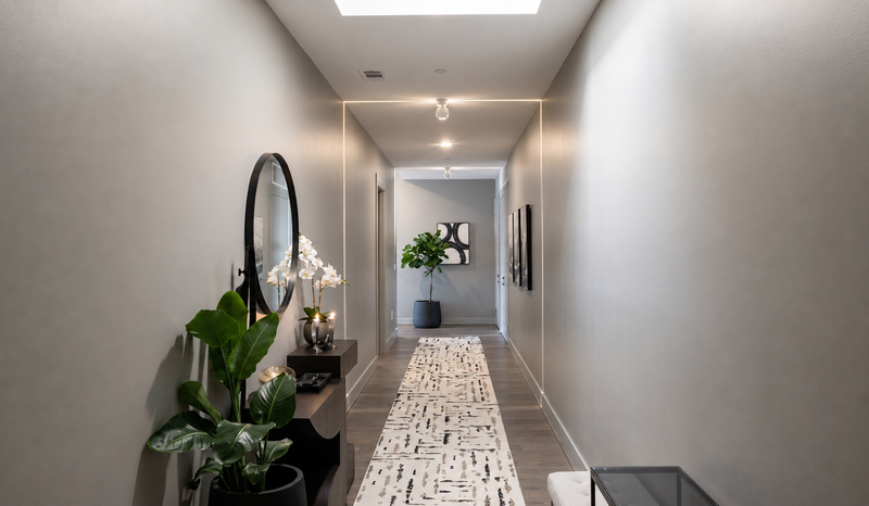 Entry hall with a round mirror, console table and a patterned stone runner