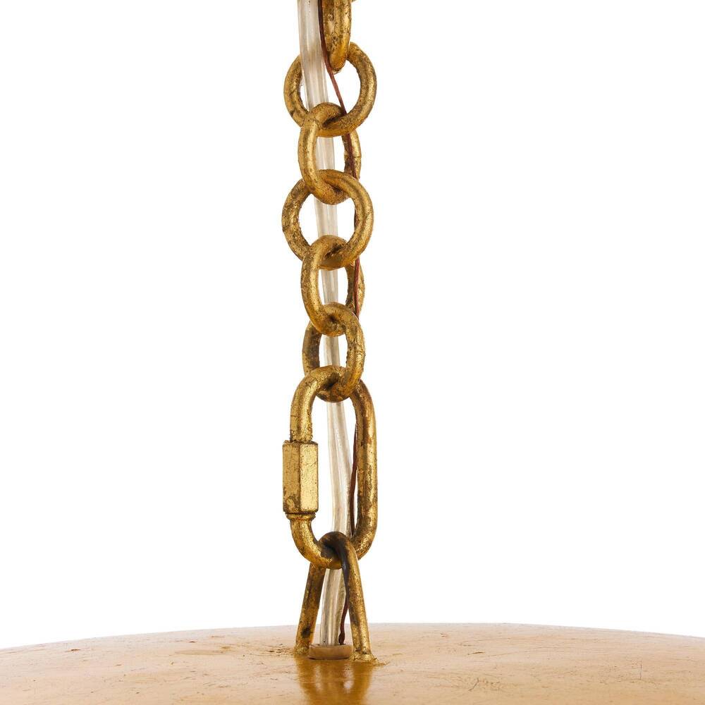 Close-up of a golden chain hanging from a wooden surface on a white background