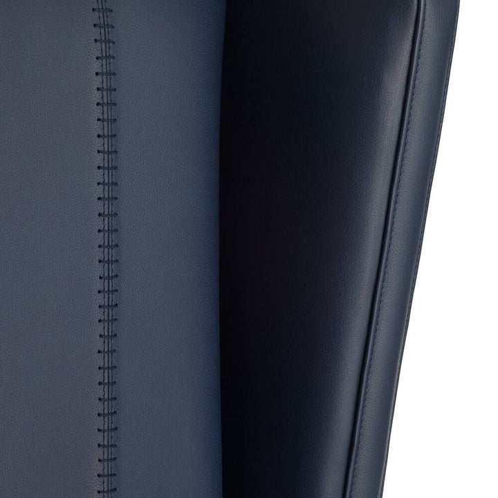 Close-up of a dark blue leather seat with stitching detail on a white background
