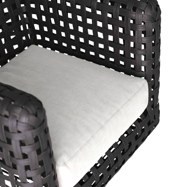 Black woven chair with a white cushion on a white background