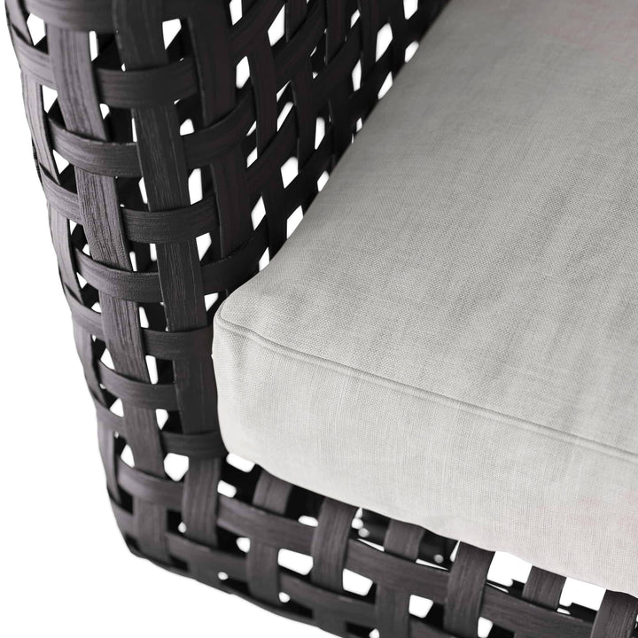 Woven chair with a white cushion on a white background