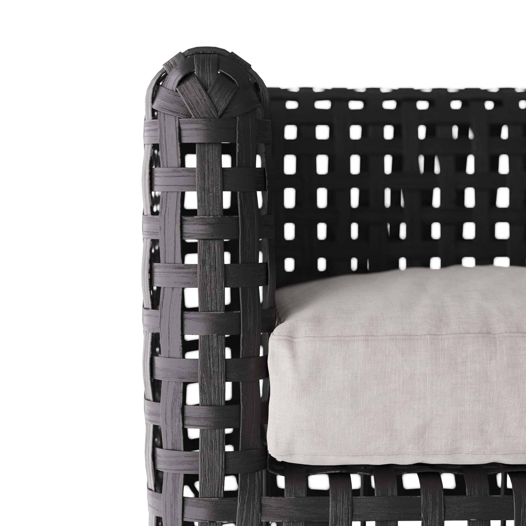 Black woven chair with a white cushion on a white background
