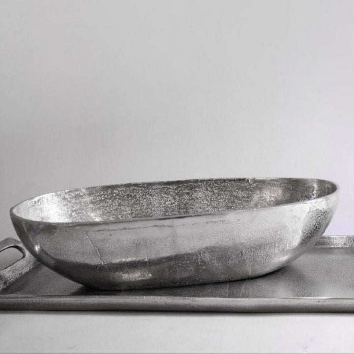 Two metallic bowls on a tray with a plain background