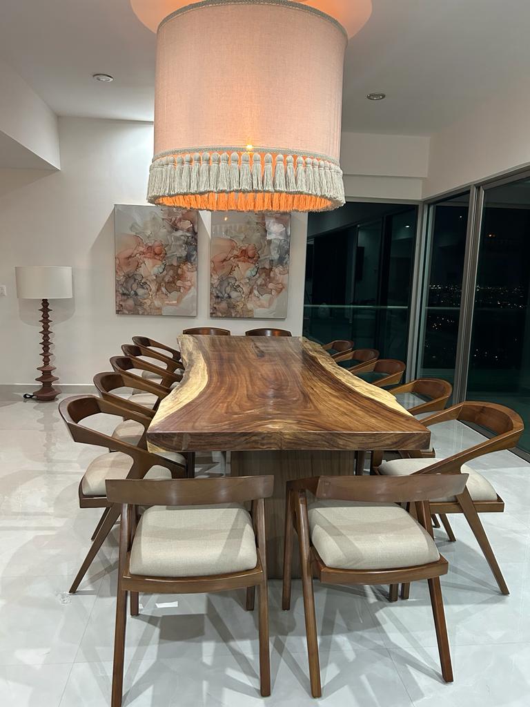 Live-edge walnut dining table with sculptural chairs and a Houston skyline view