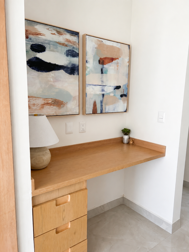 Entry vignette with a floating oak shelf, ceramic table lamp and paired abstract artwork