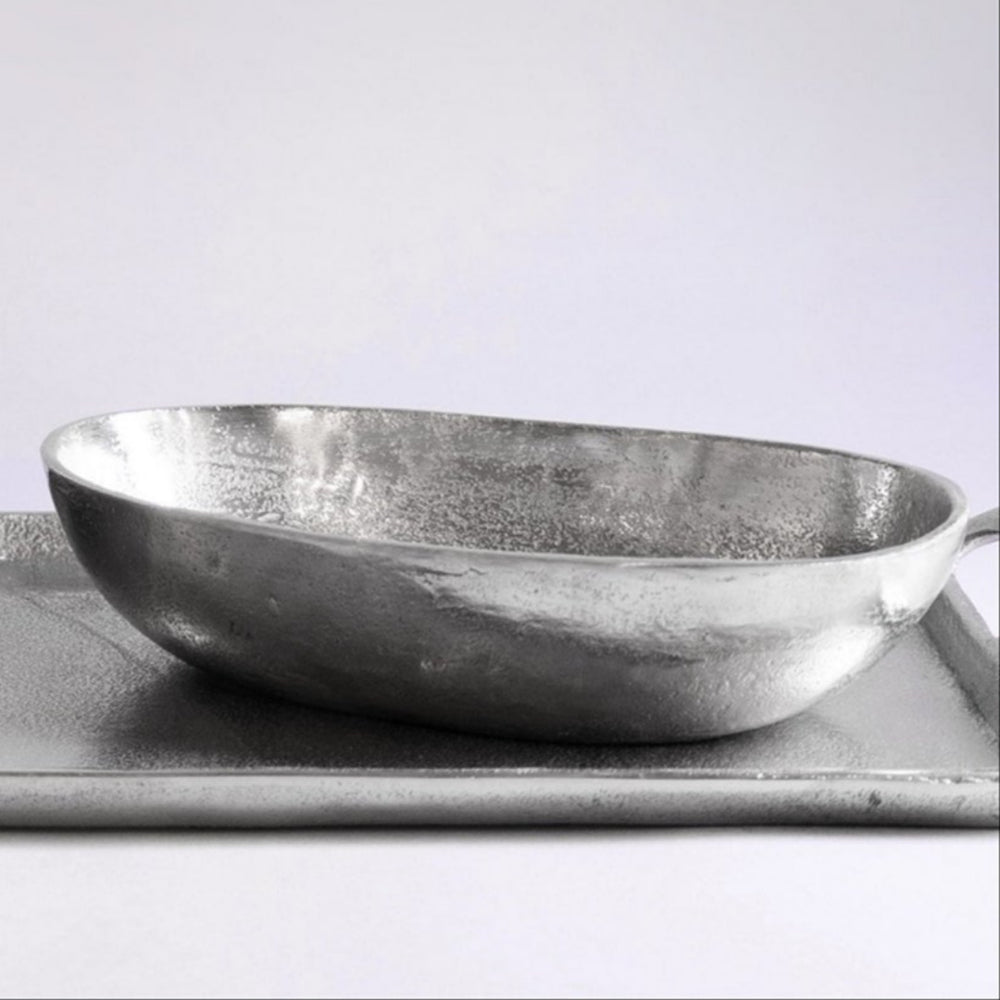 Metallic bowl on a tray with a plain background