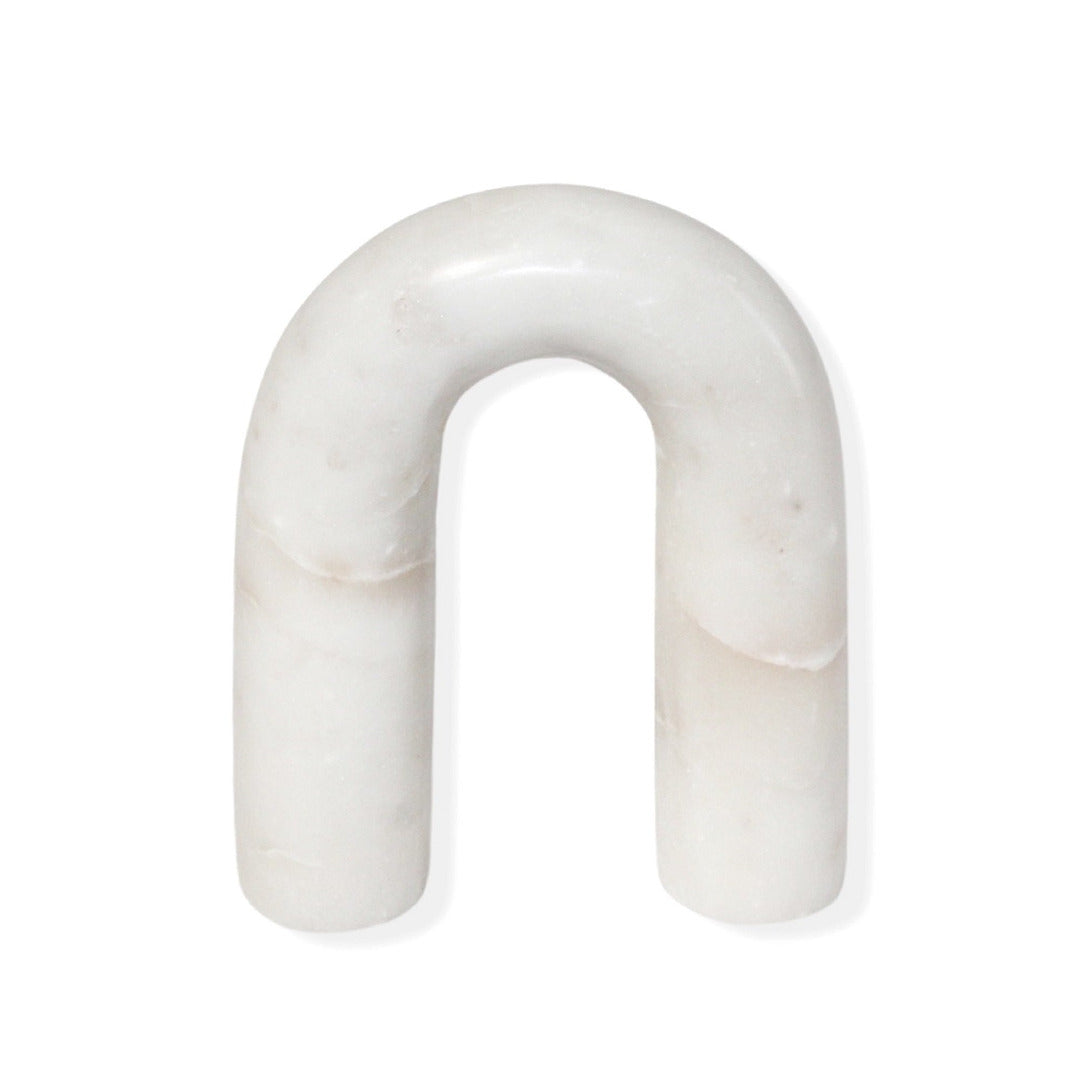 White arch-shaped marble figurine on a white background