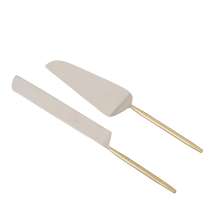 Two metal dessert servers with gold handles on a white background