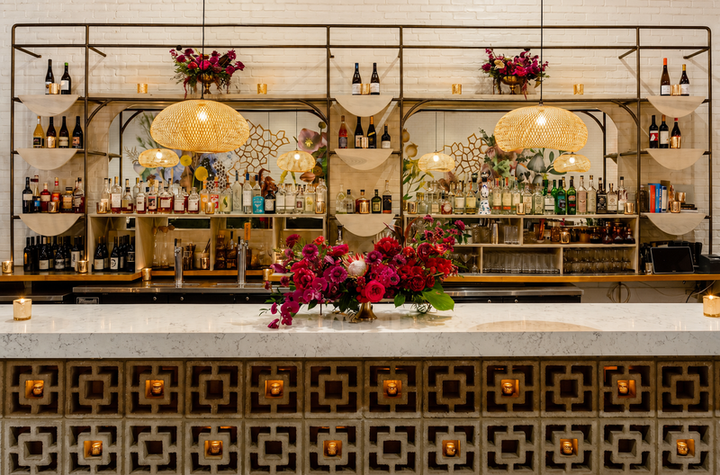 Arched backbar with brass shelving, bottle display and a fluted stone base