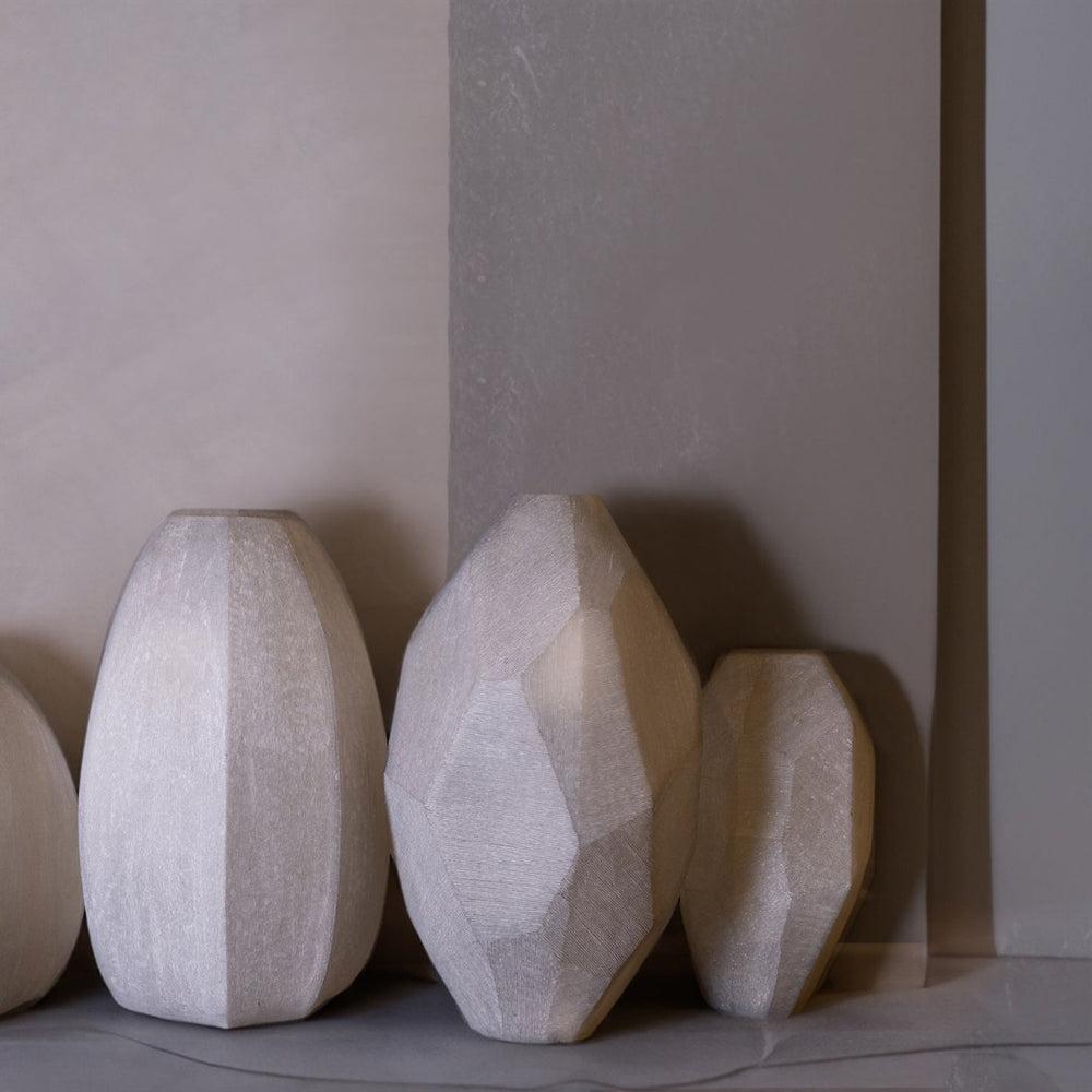 Set of three glass vases on a neutral background