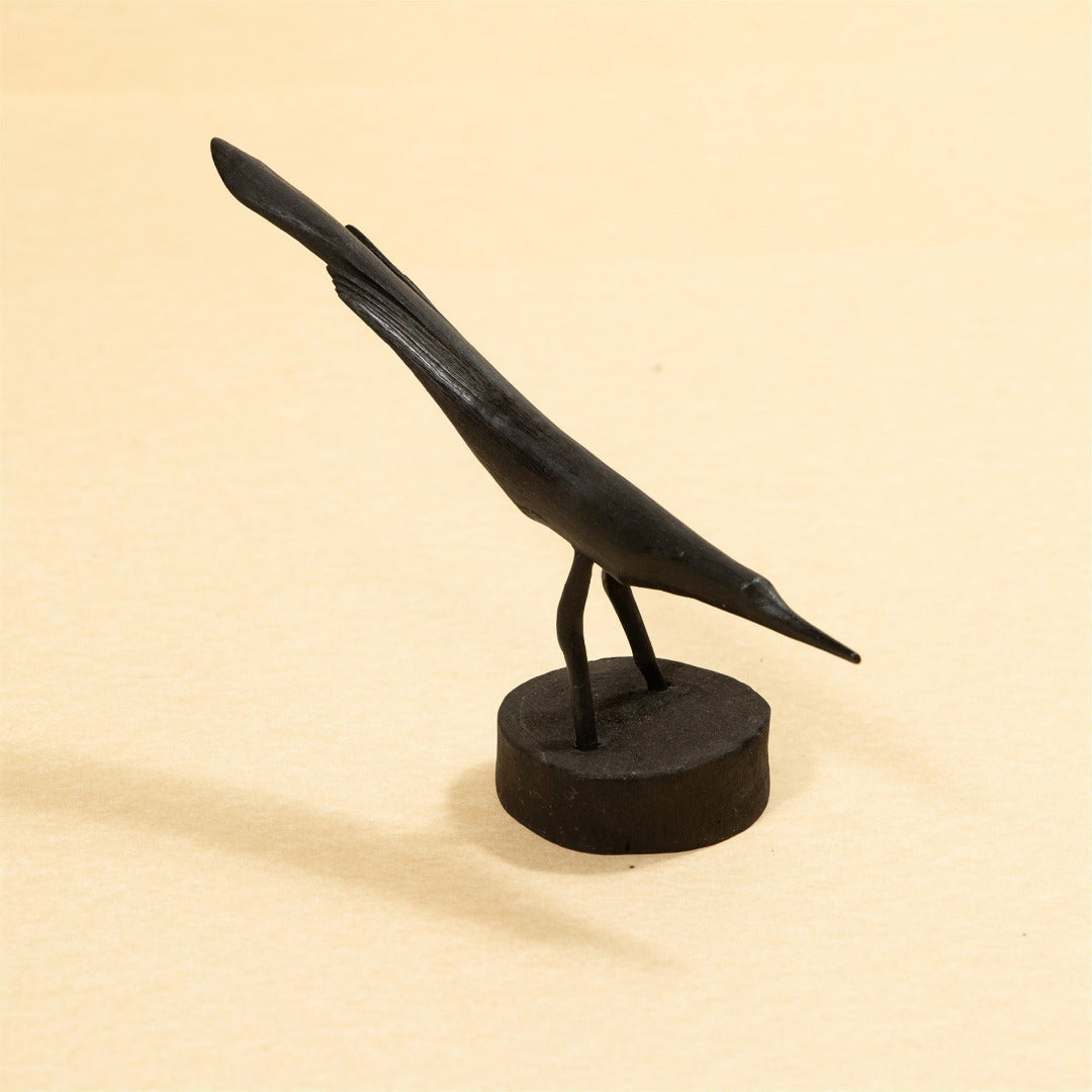 Black bird sculpture on a beige background